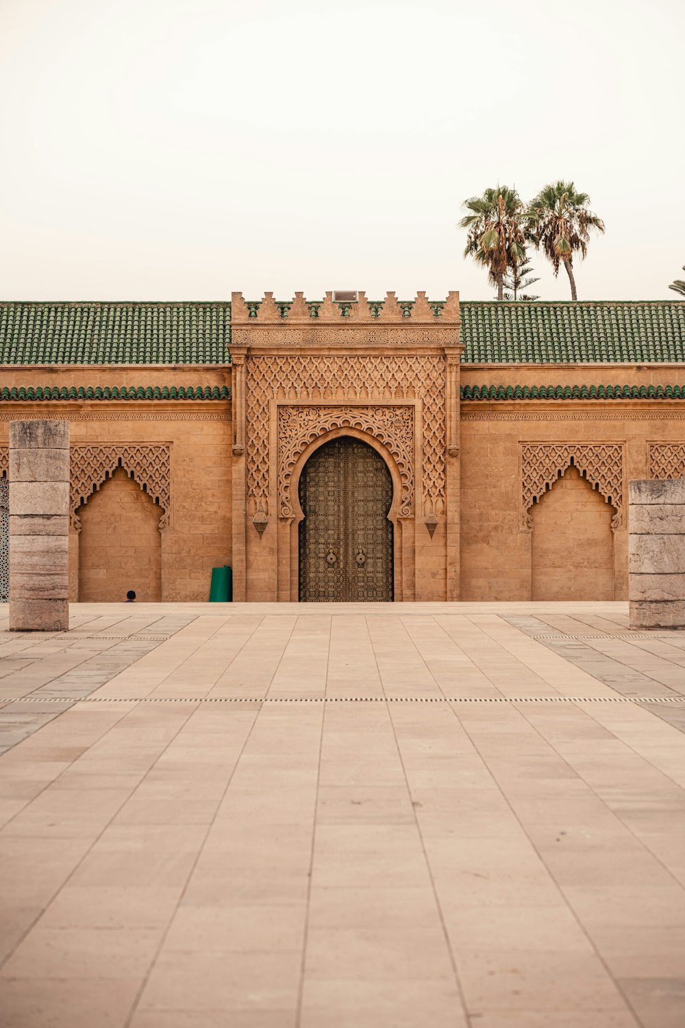 a building with a large door and a palm tree