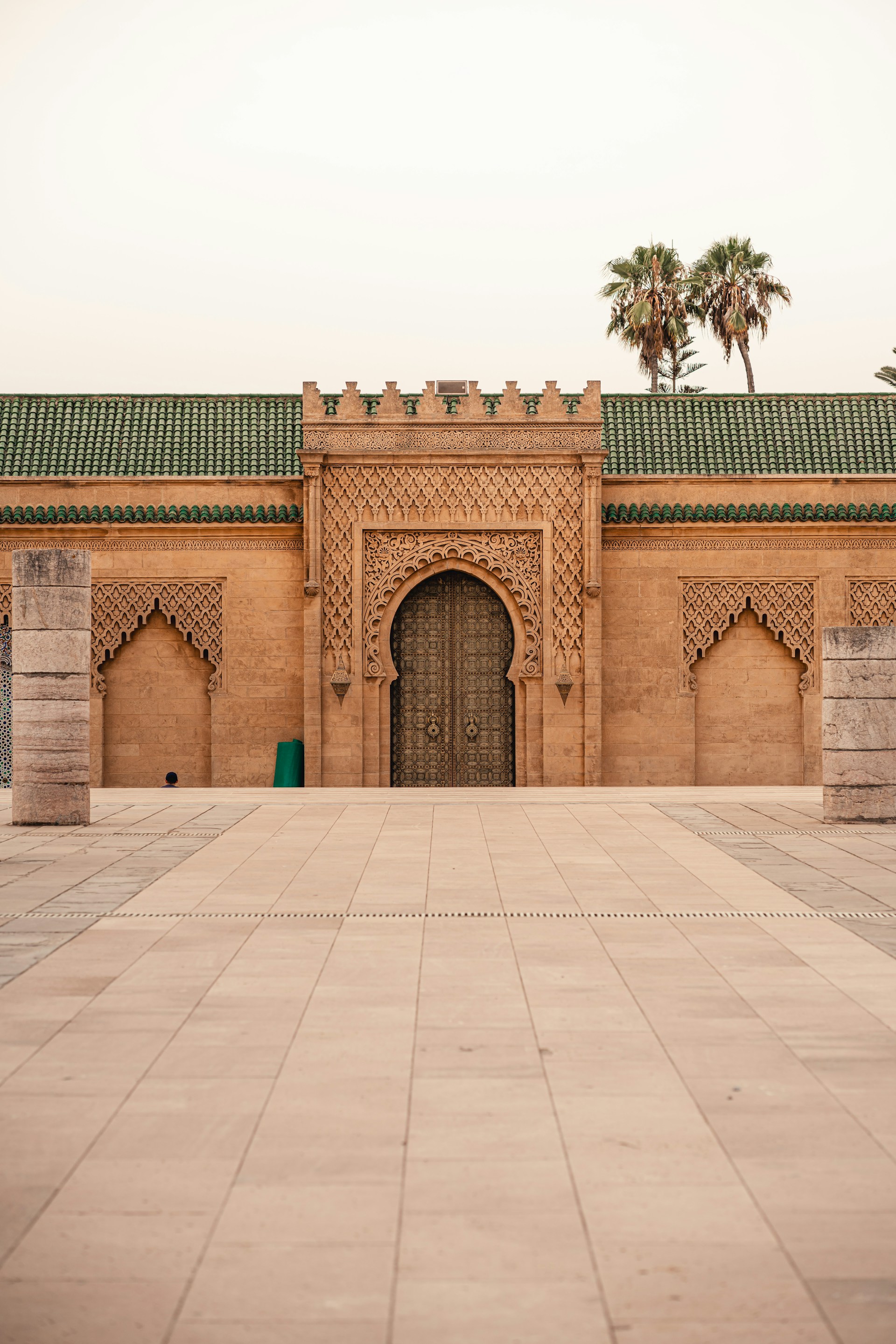 a building with a large door and a palm tree
