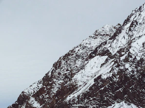 A rugged mountain peak under a dark sky symbolizing endurance and challenge.