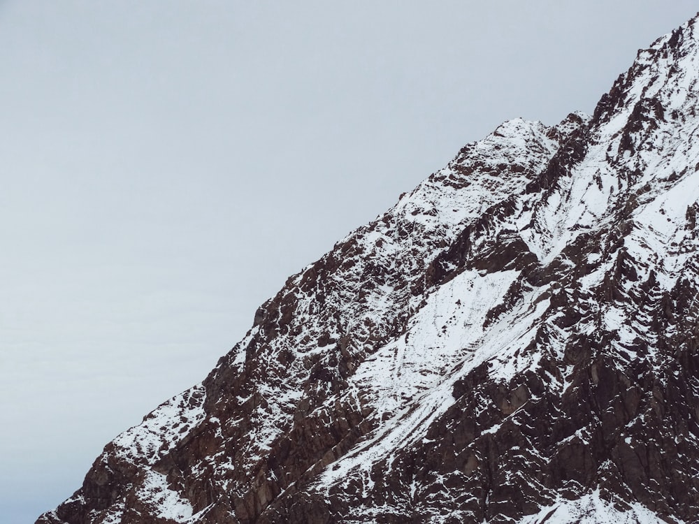 ein schneebedeckter Berg mit einem Skilift im Hintergrund