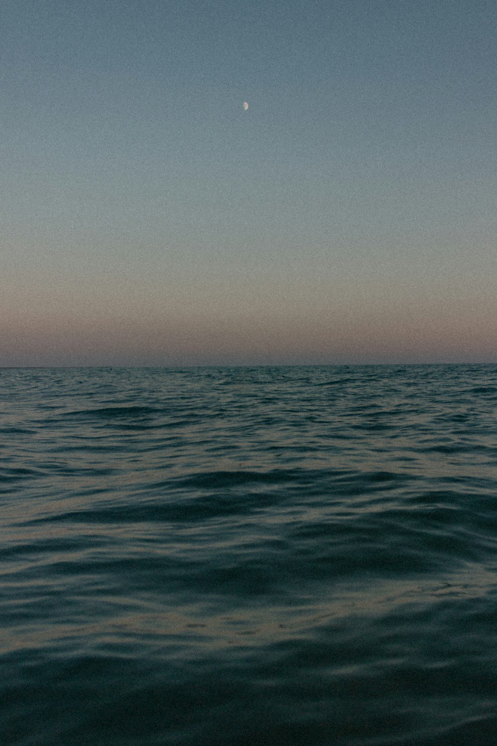 un cuerpo de agua con una luna en el cielo