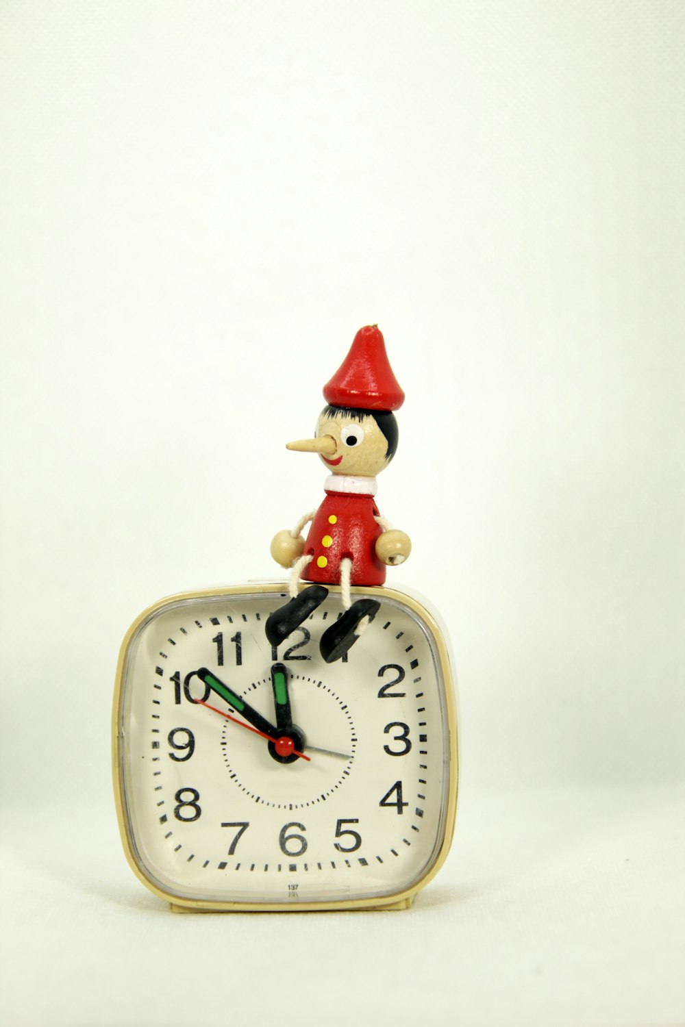 a clock with a gnome sitting on top of it