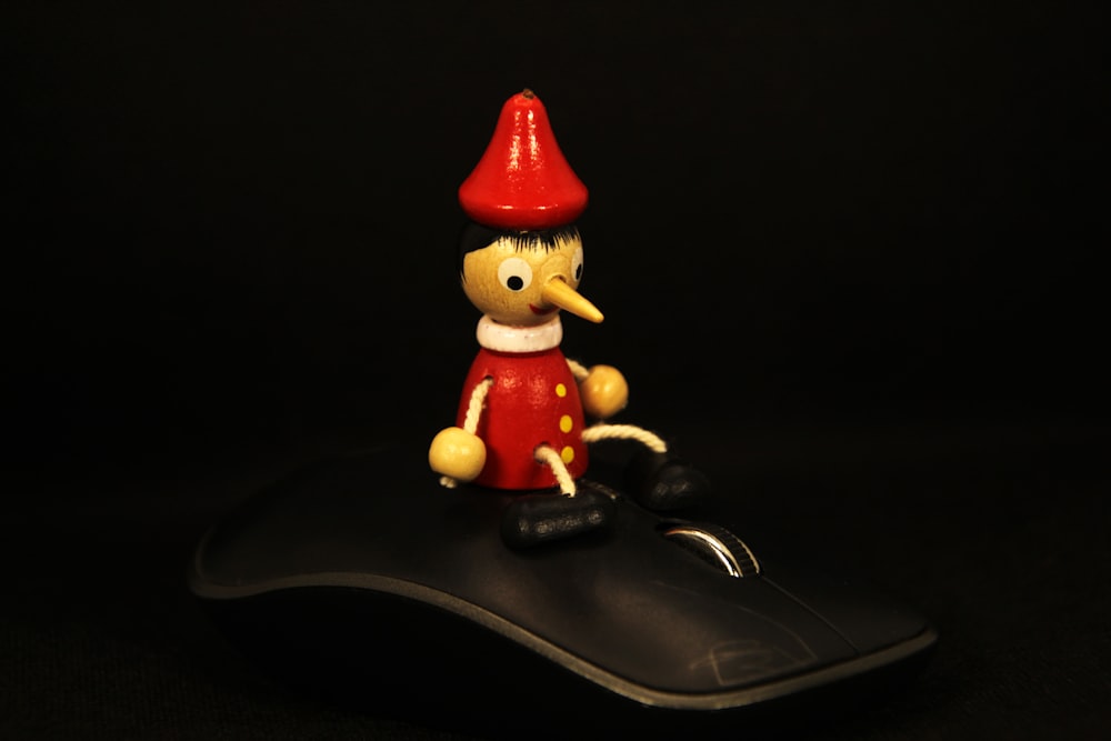 a small toy sitting on top of a computer mouse