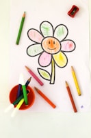 a child's drawing of a flower with crayons