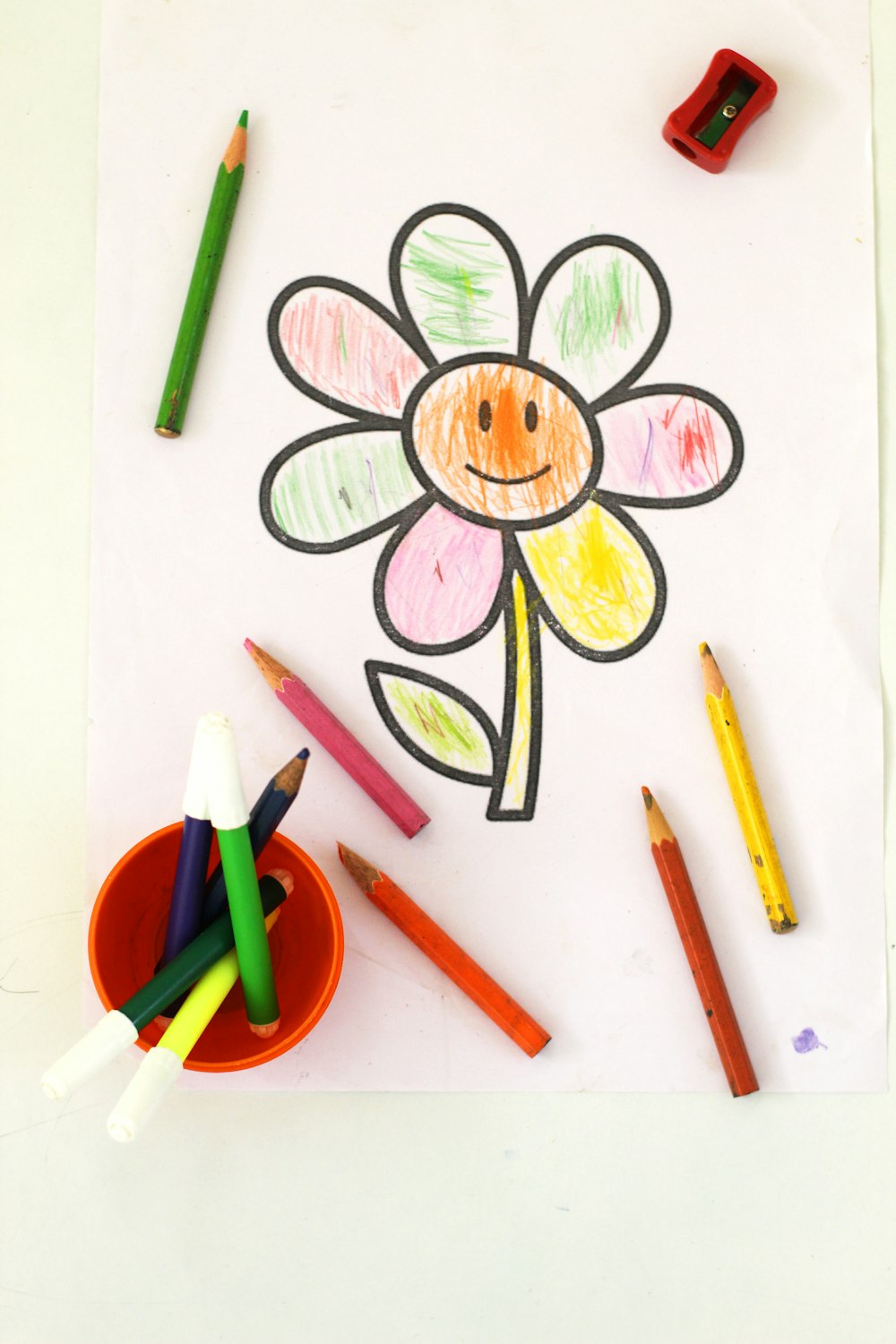 a child's drawing of a flower with crayons
