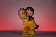 An elegant figurine of intertwined lilies in muted dusty rose and warm gray tones, capturing a tender moment.