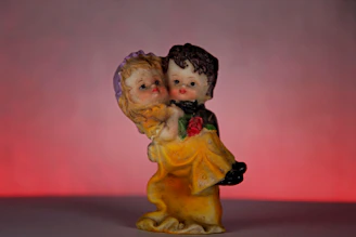A delicate resin figure of a romantic couple embracing under a blooming cherry tree.
