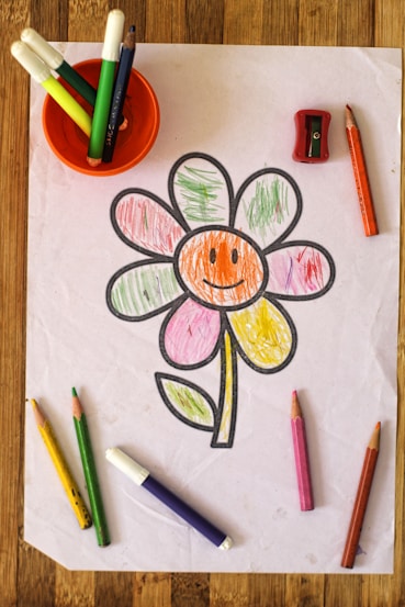 a child's drawing of a flower with crayons