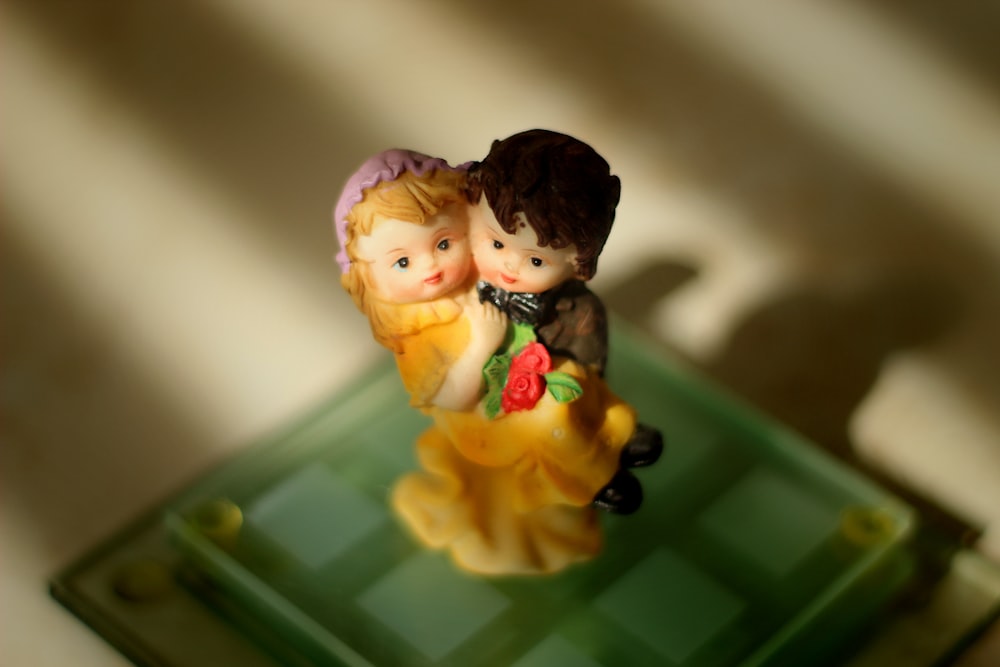 a couple of figurines sitting on top of a green tray