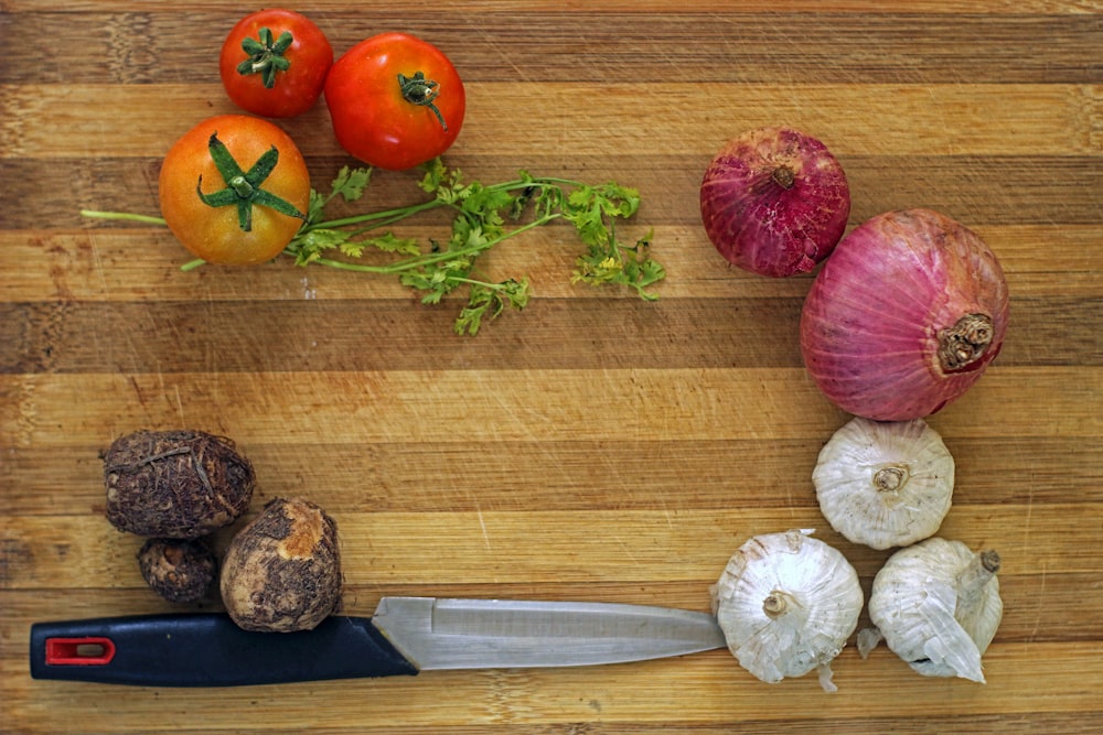 a cutting board topped with vegetables and a knife