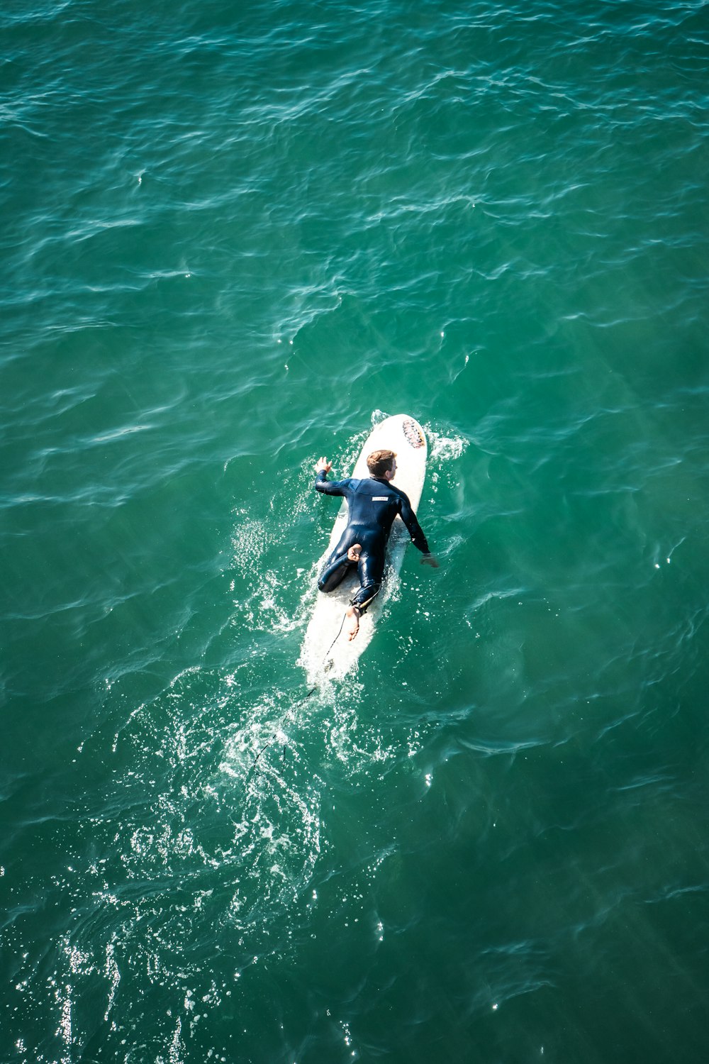a man riding a surfboard on top of a body of water
