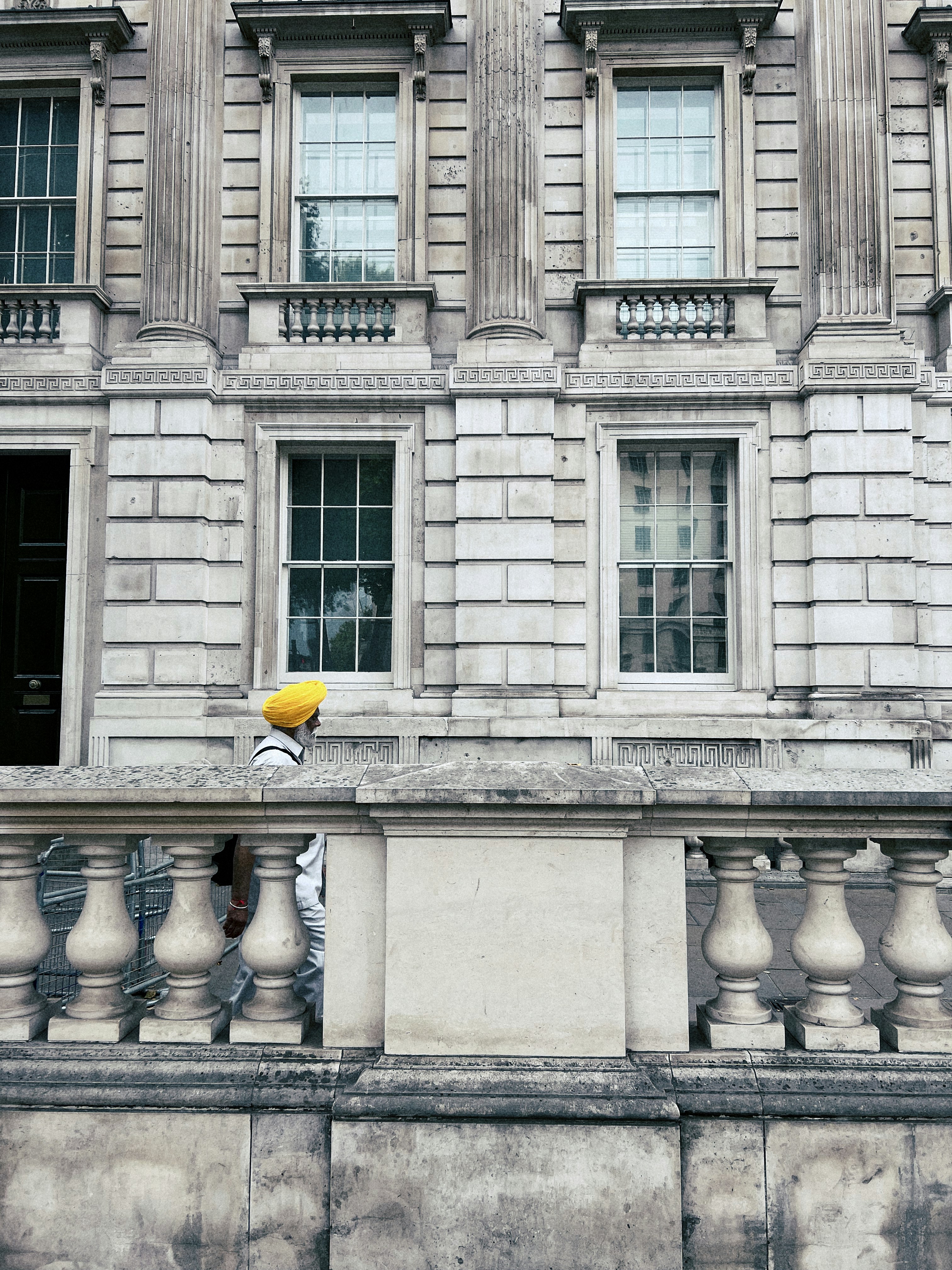 une personne avec un parapluie jaune debout sur un balcon