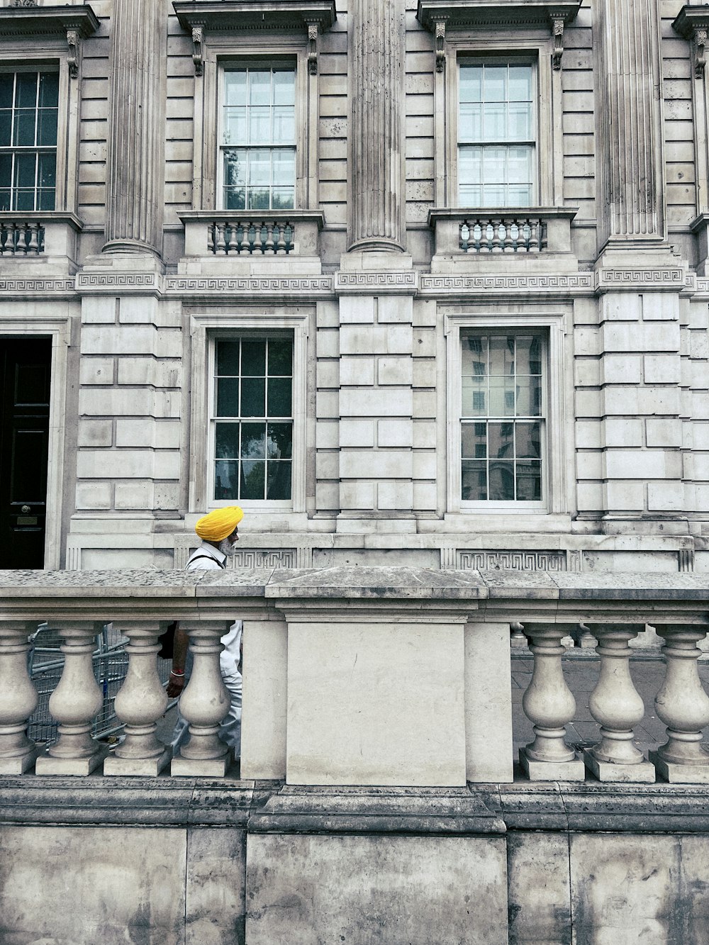 a person with a yellow umbrella standing on a balcony