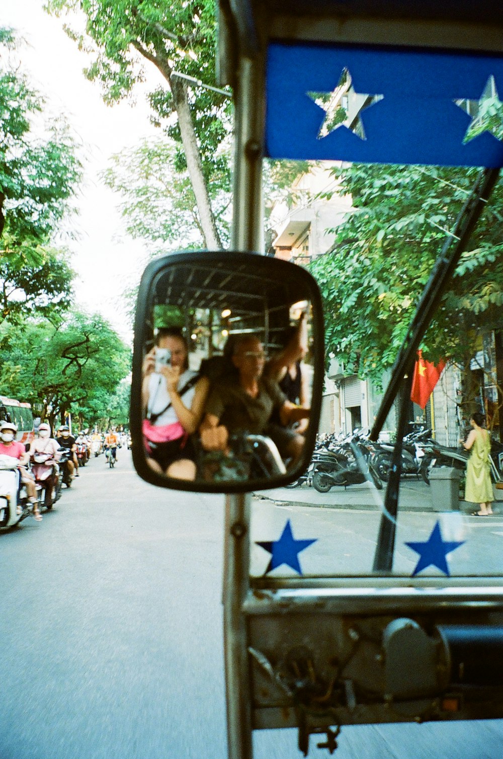 a rear view mirror of a bus with people in it