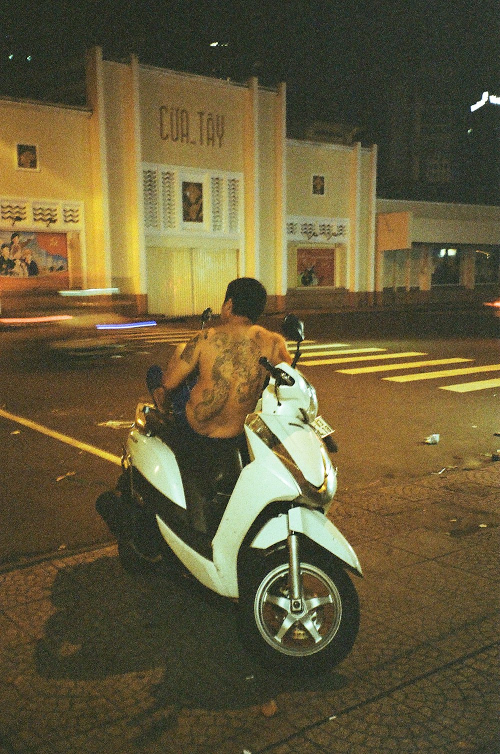 a man riding a motorcycle down a street at night