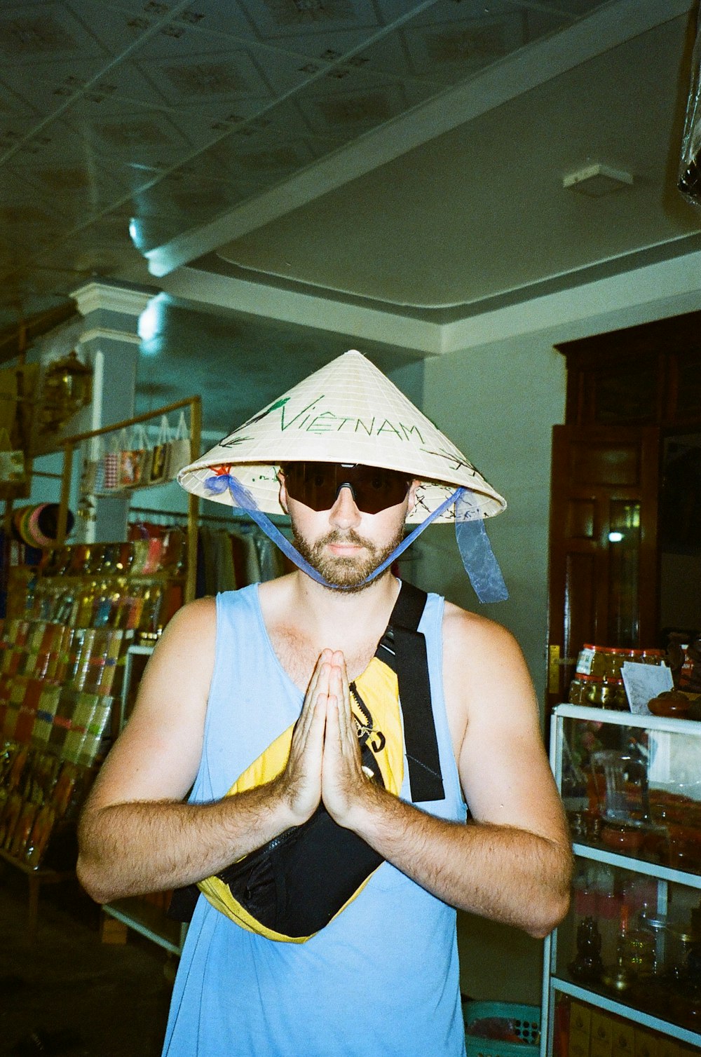 a man wearing a straw hat and holding his hands together