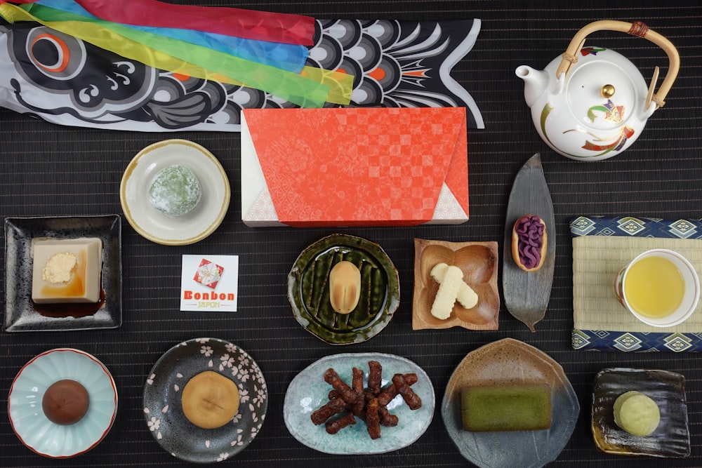 a table topped with plates of food and a tea pot