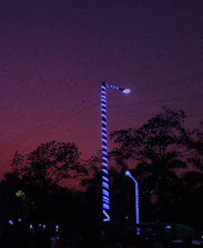 Technicians installing LED outdoor lights on a city street at dusk.