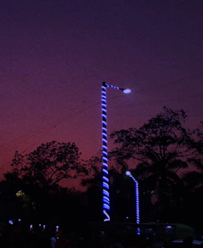 Technicians installing LED outdoor lights on a city street at dusk.