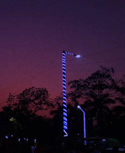 A technician installing LED streetlights on a municipal road at dusk.