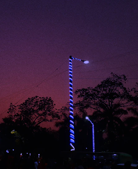 A technician installing LED streetlights in a small town at dusk.