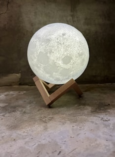 Close-up of a personalized 3D printed moon lamp glowing softly on a decorated event table