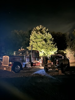 Night scene of a tow truck assisting a stranded vehicle.