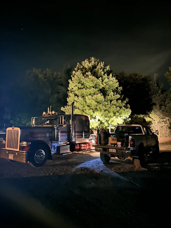 Nighttime roadside scene showing a Rutaviva tow truck with lights on, ready for action.