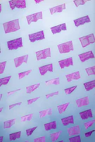 Artisan carefully cutting intricate designs into vibrant sheets of papel picado.