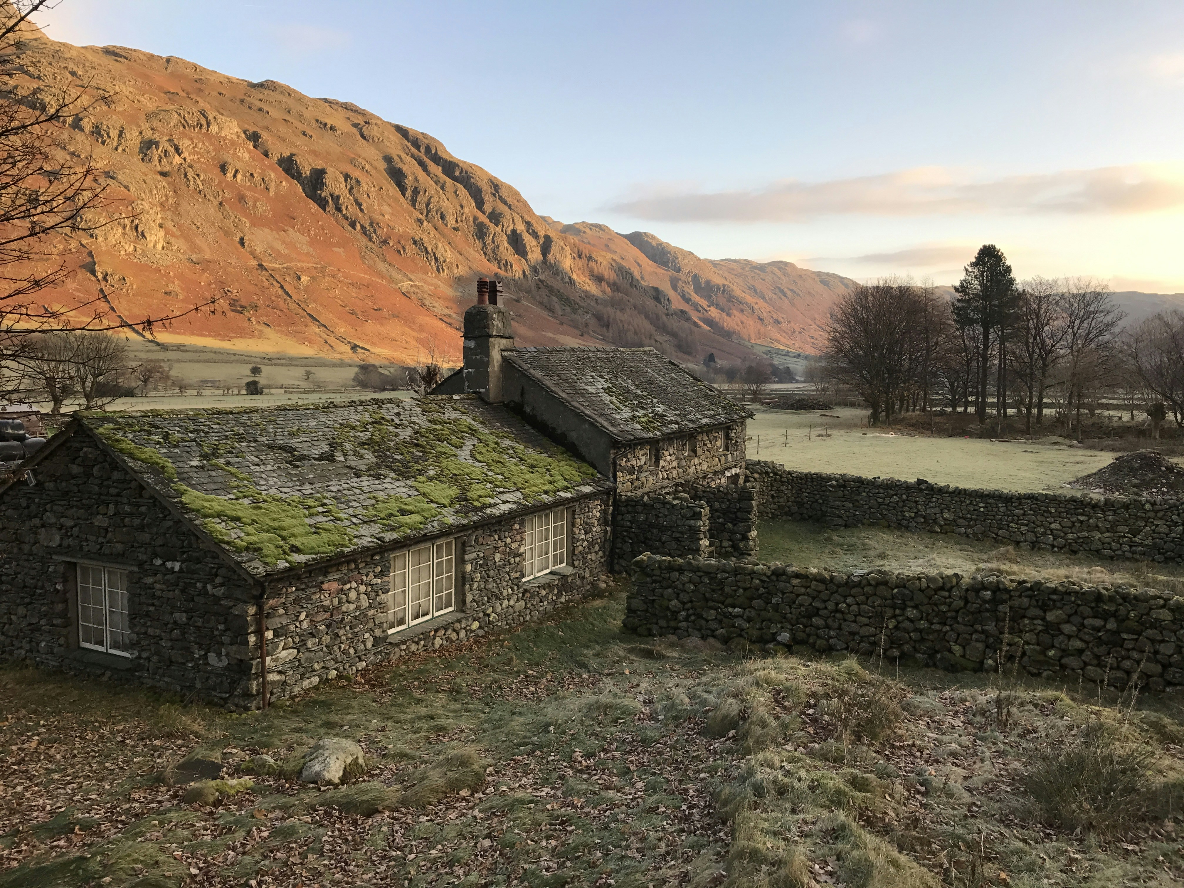 an old stone house with a green roof