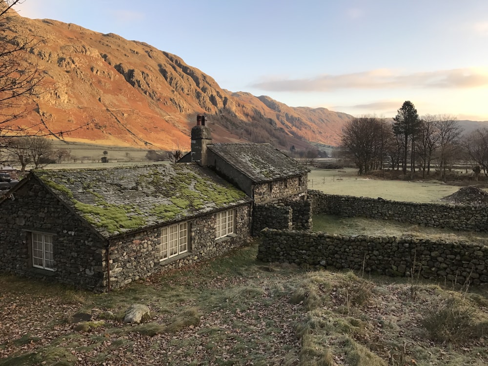 an old stone house with a green roof