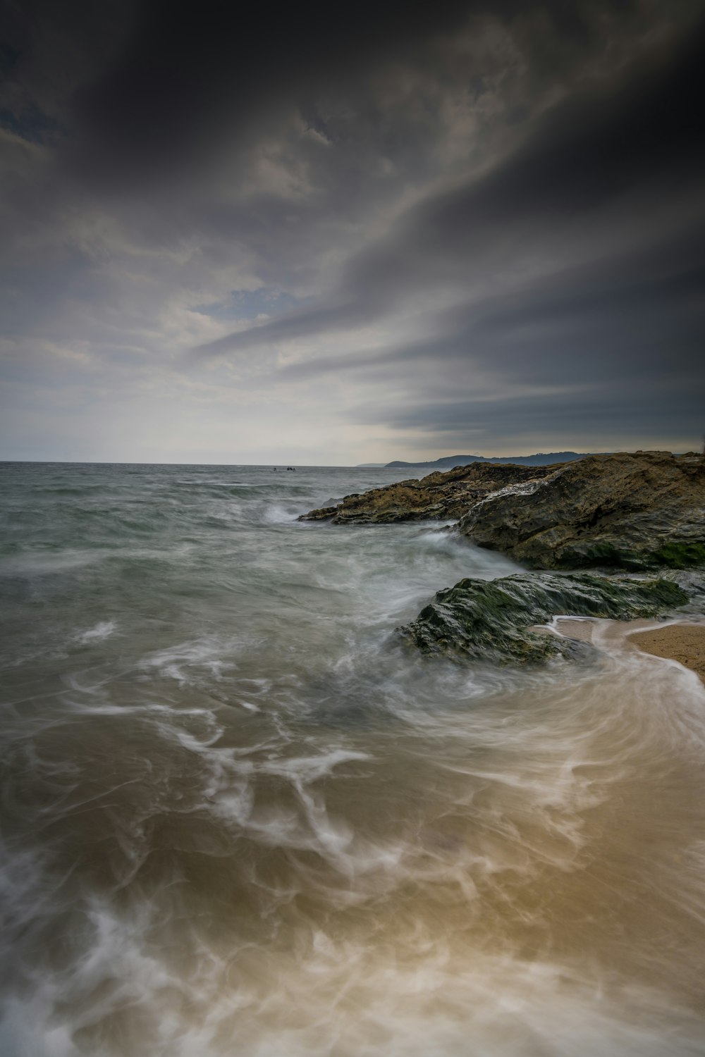 a rocky beach with waves coming in to shore