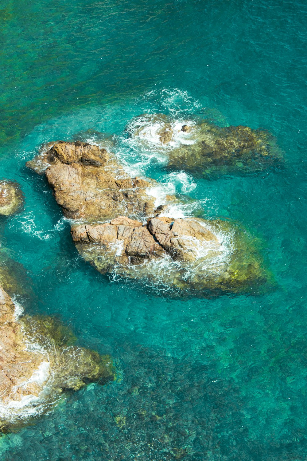 a group of rocks sitting in the middle of a body of water