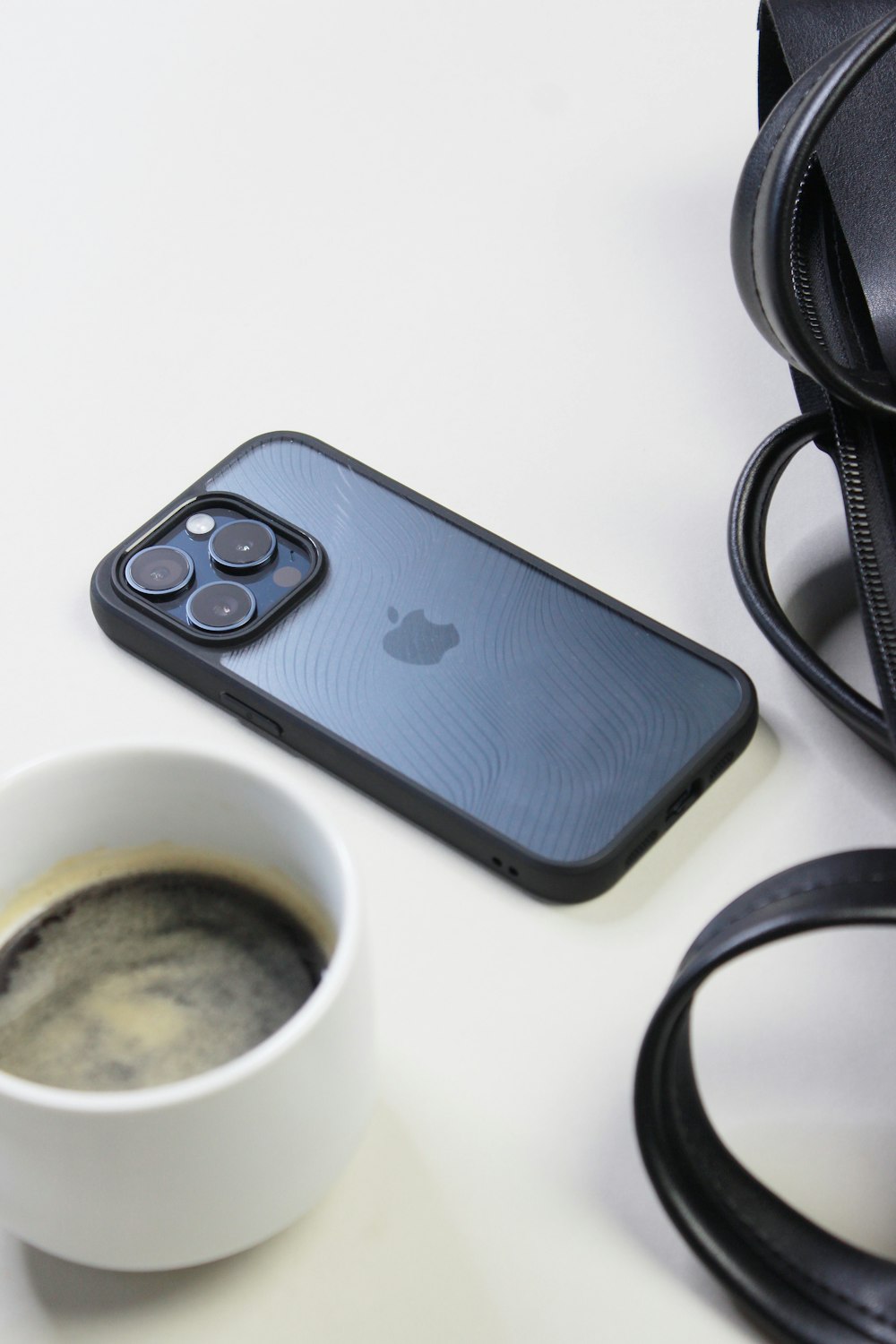 a cup of coffee next to an iphone