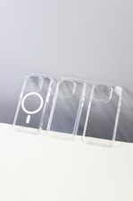 User easily attaching a MagSafe-compatible transparent case to an iPhone.