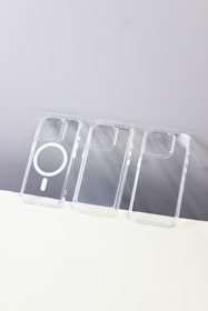 User easily attaching a MagSafe-compatible transparent case to an iPhone.