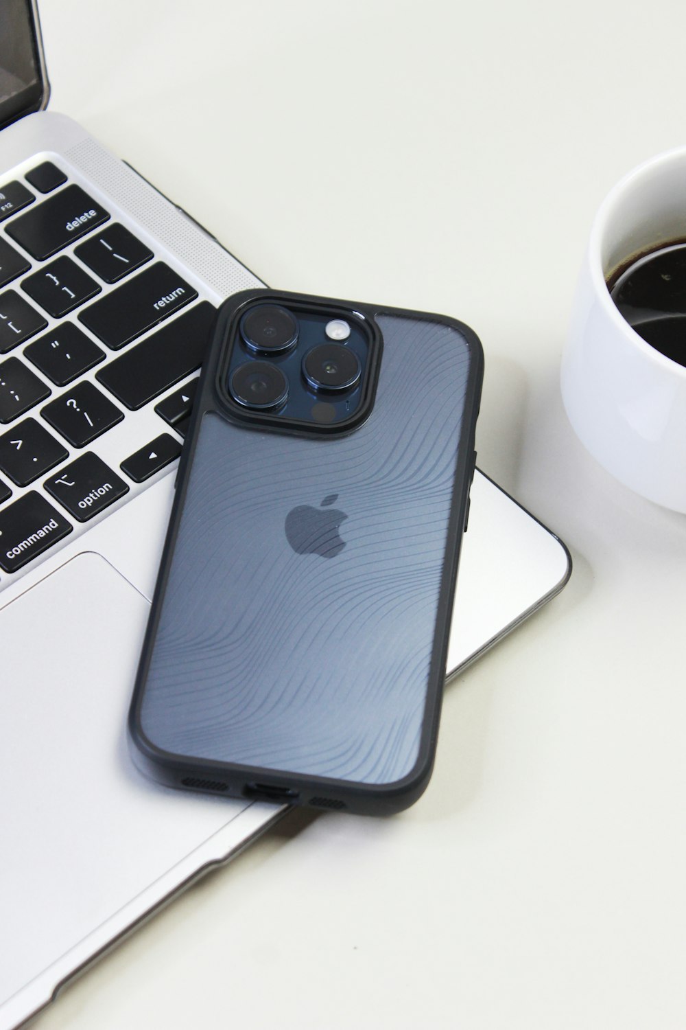 an iphone and a cup of coffee on a table