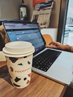 Close-up of hands typing on a keyboard with a cup of coffee nearby, representing online shopping convenience
