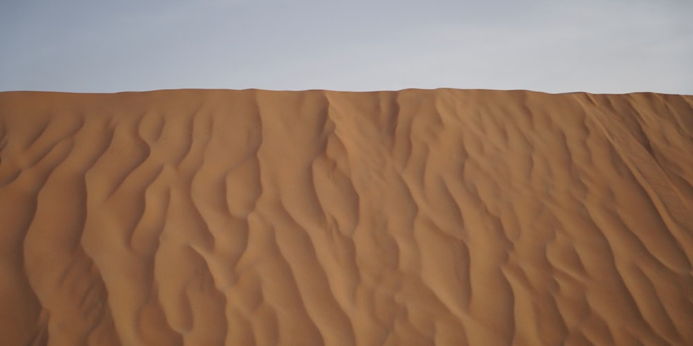 a large sand dune with a sky background