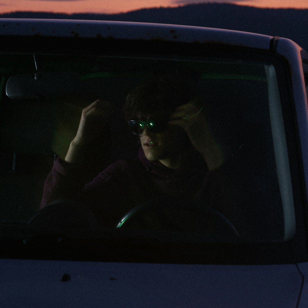 a person sitting in a car in the dark