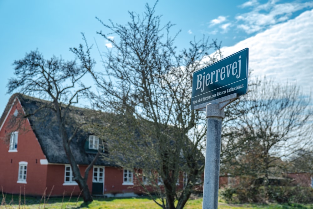 a street sign in front of a red house