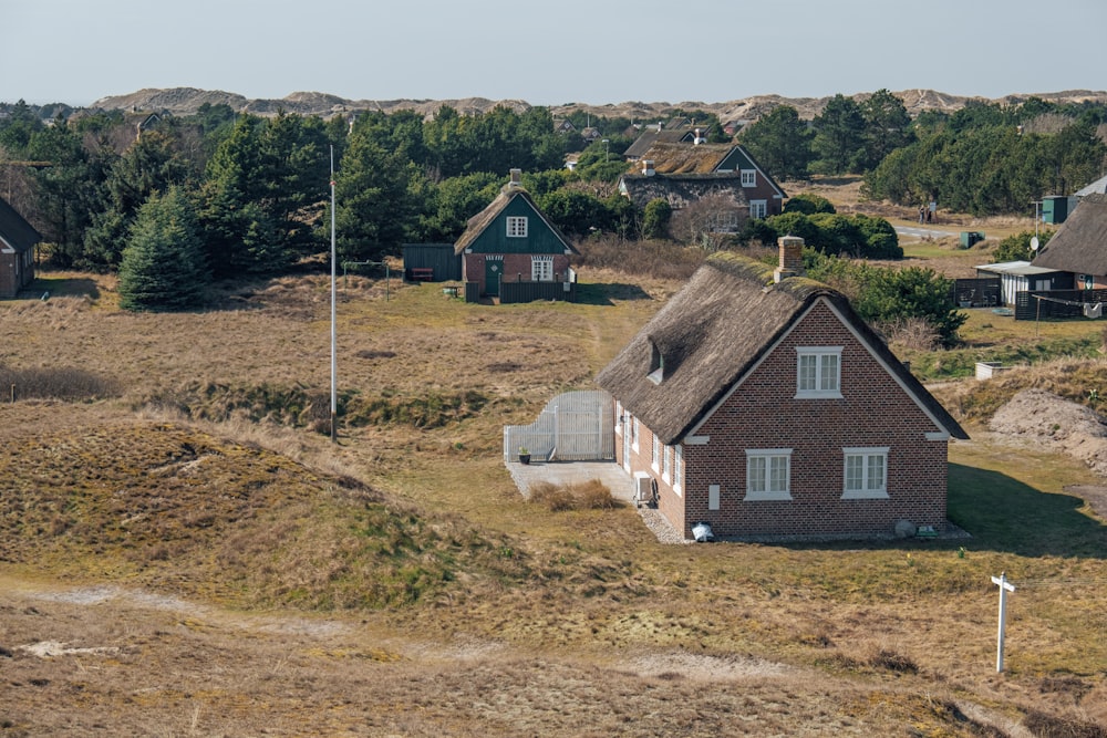 a small house with a thatched roof in a field