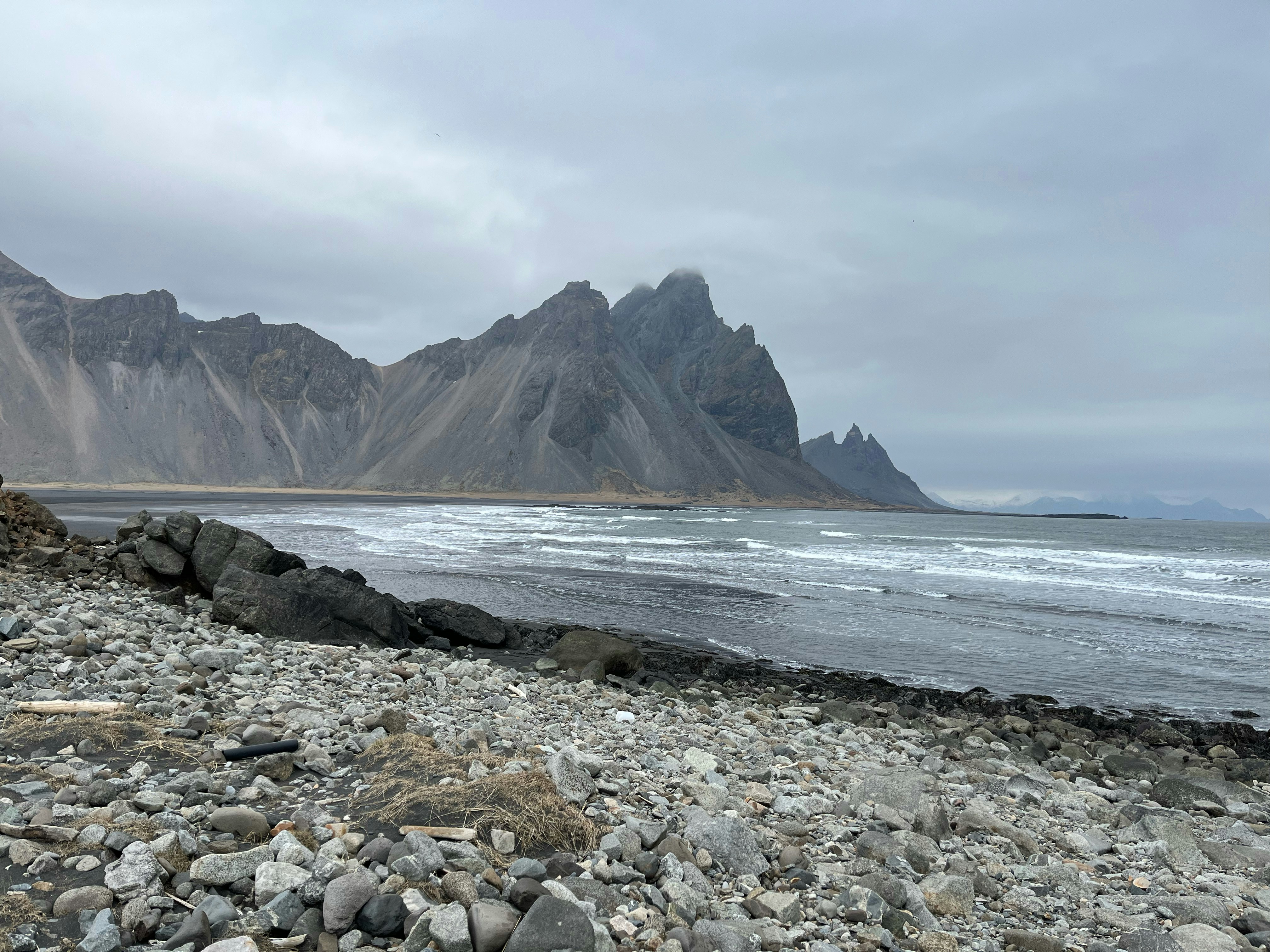 a rocky beach with a mountain in the background