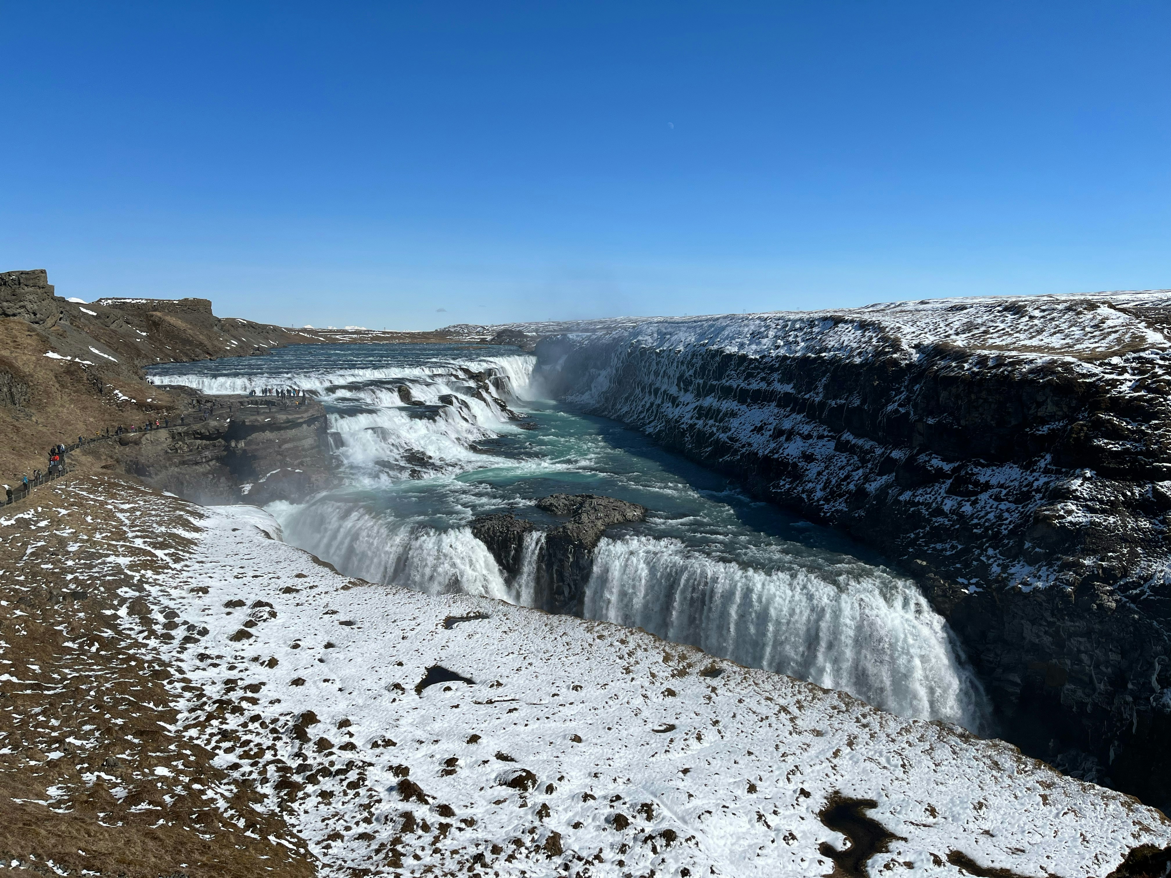 a view of a waterfall in the middle of a snowy landscape
