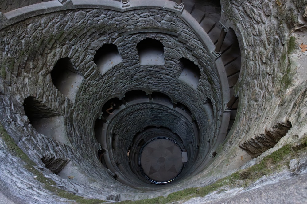 a spiral staircase in a stone building with moss growing on the sides