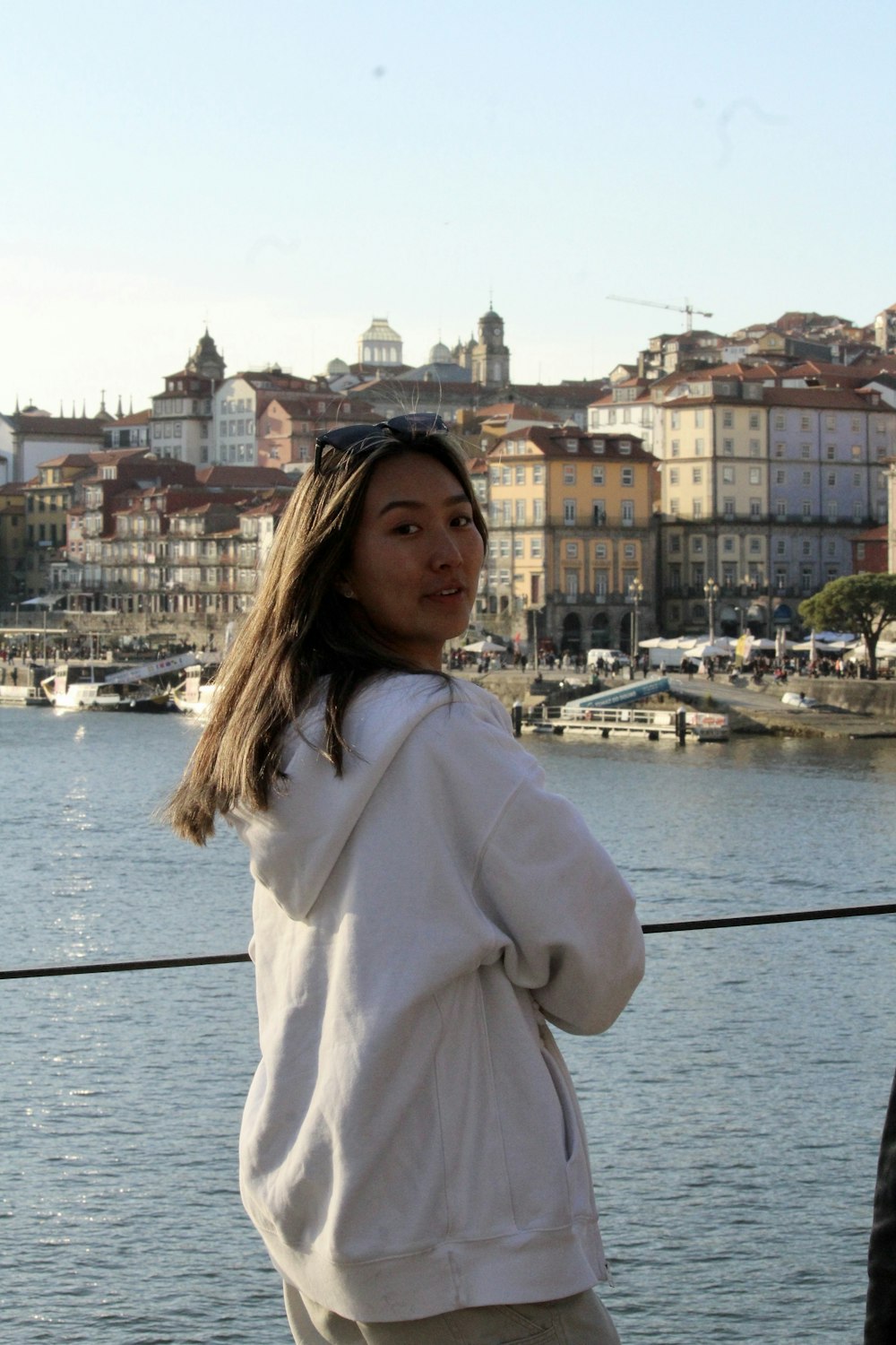 a woman standing next to a body of water