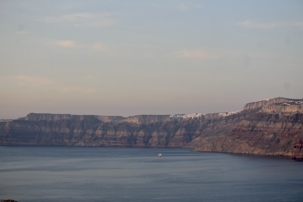 a large body of water with a mountain in the background