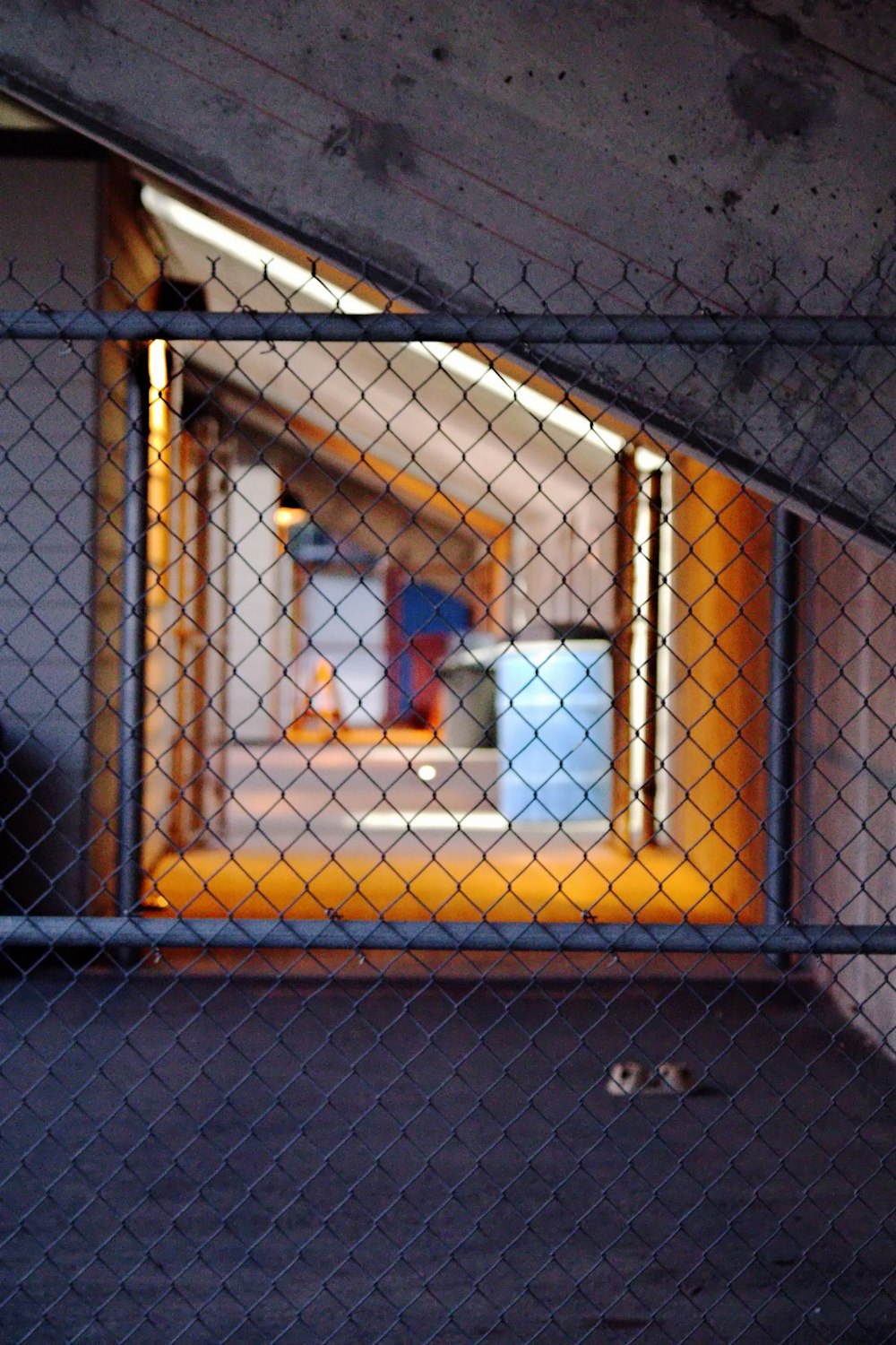 a view of a hallway through a chain link fence