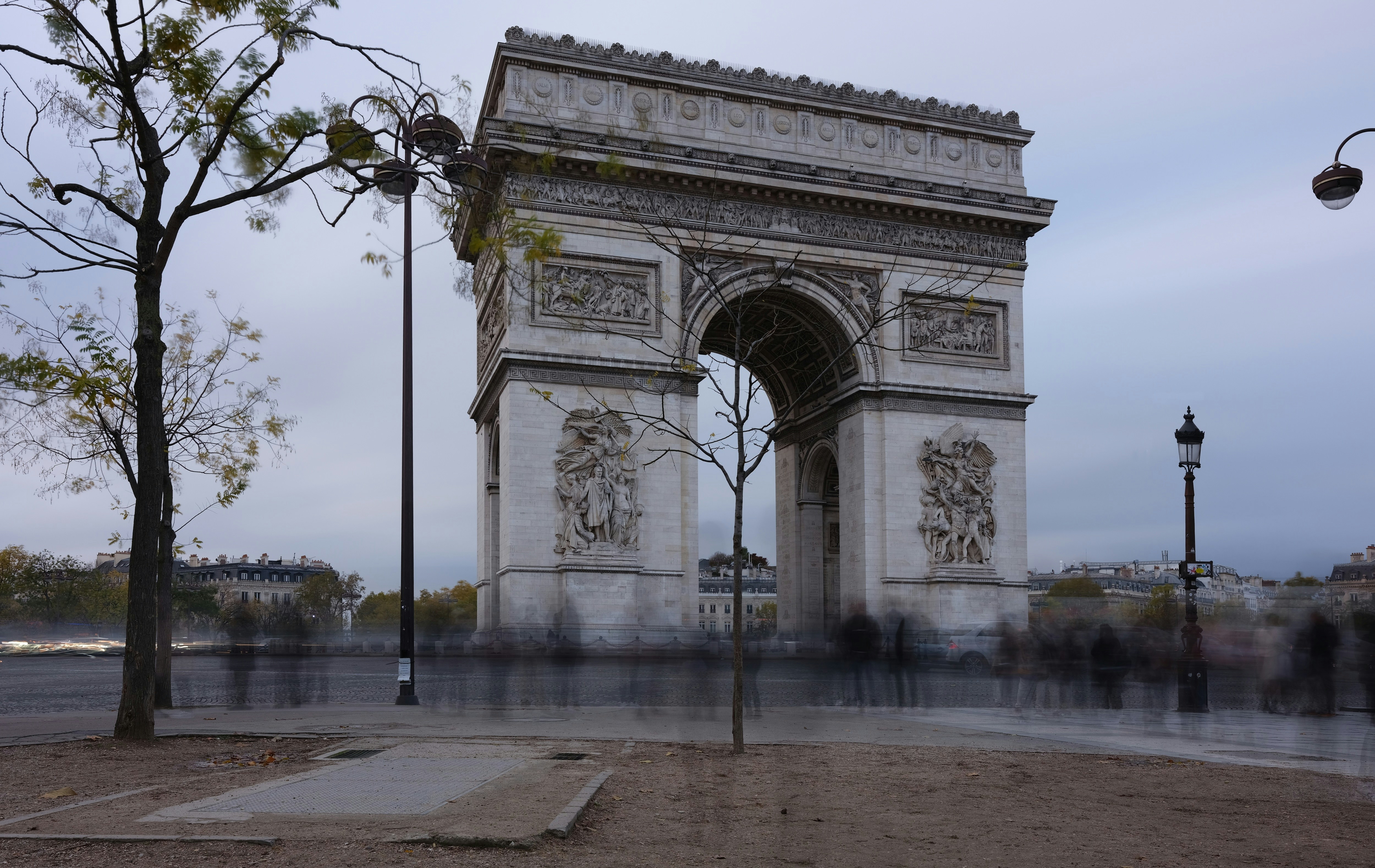 a group of people standing in front of the arc of triumph
