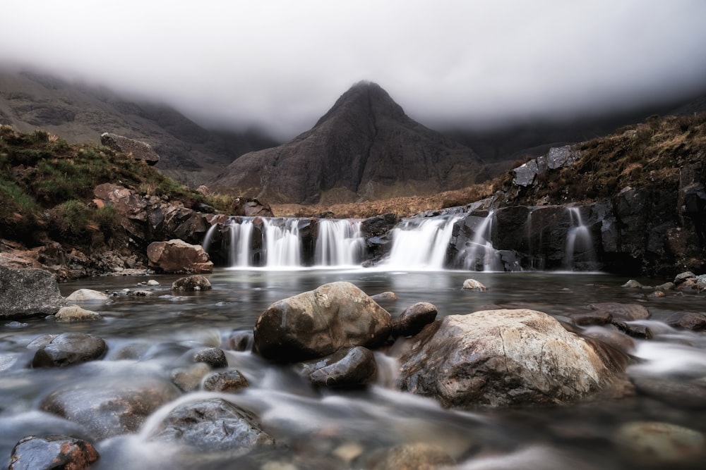 a small waterfall in the middle of a mountain